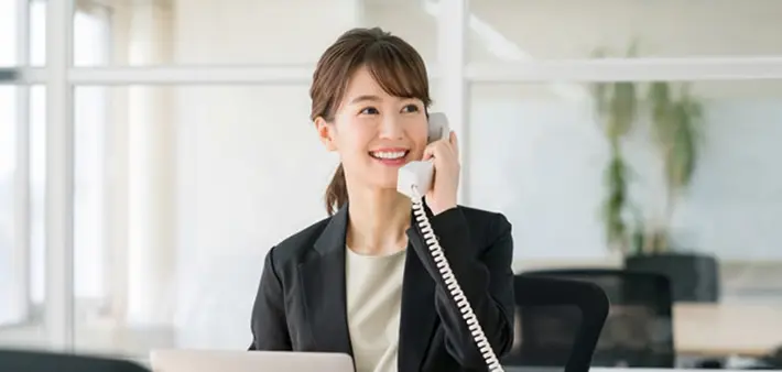 電話で応対する笑顔の女性