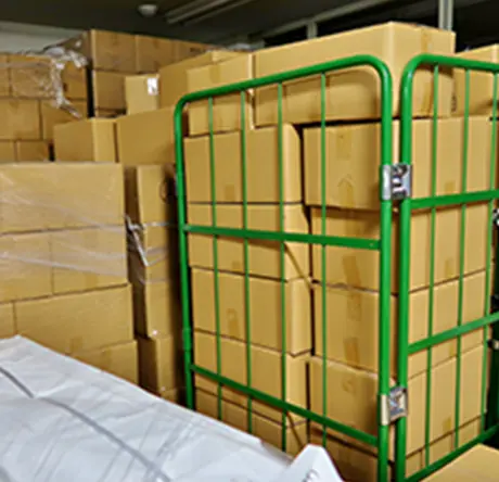 倉庫に積まれた多数の段ボール箱と台車